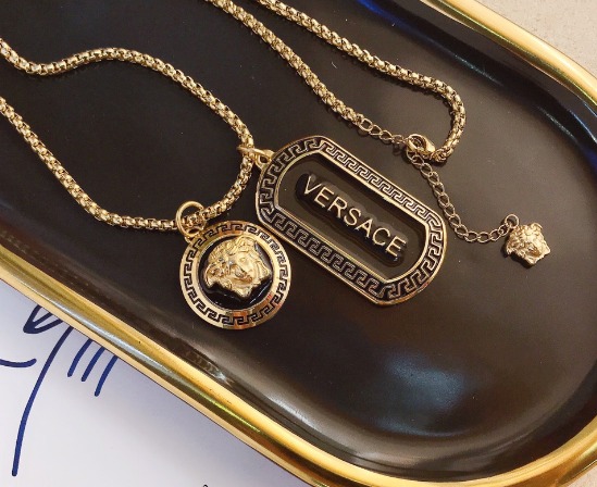 سلسلة ذهبية بتصميم مستوحى من Versace مع تعليقة ميدوسا ونقشة يونانية.